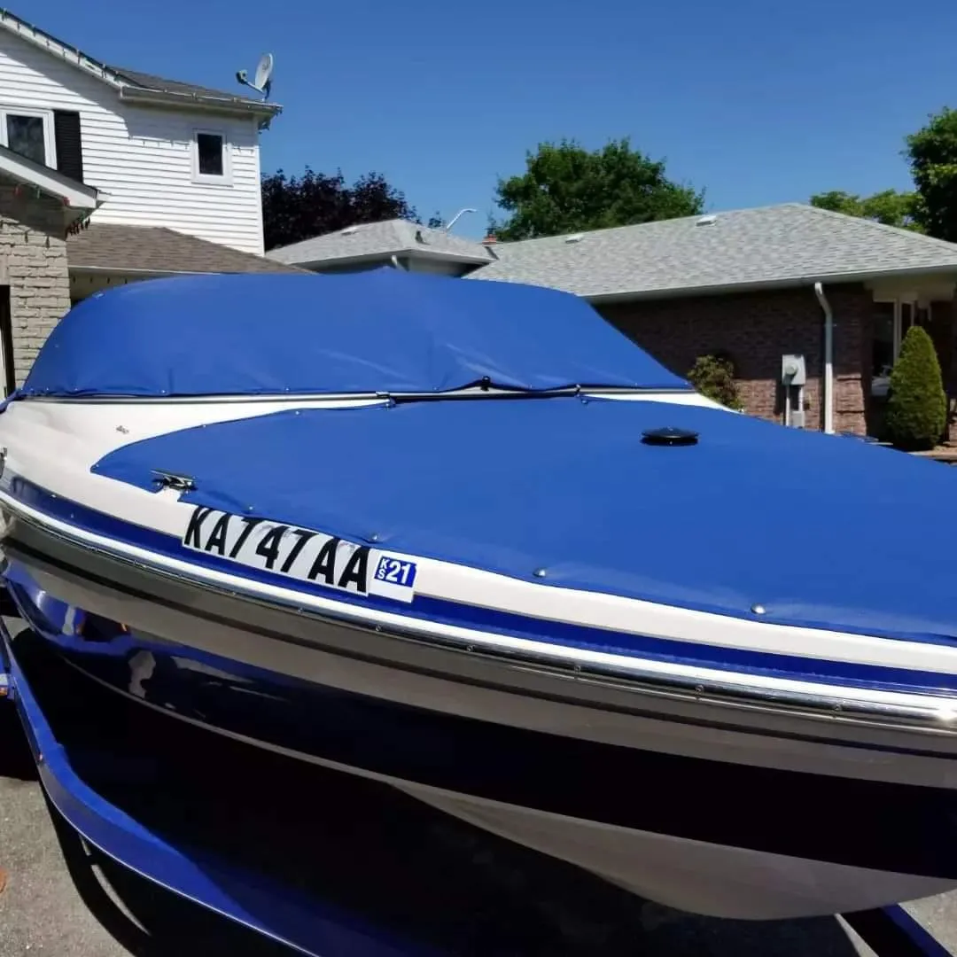 Custom fitted blue boat cover on a trailered boat